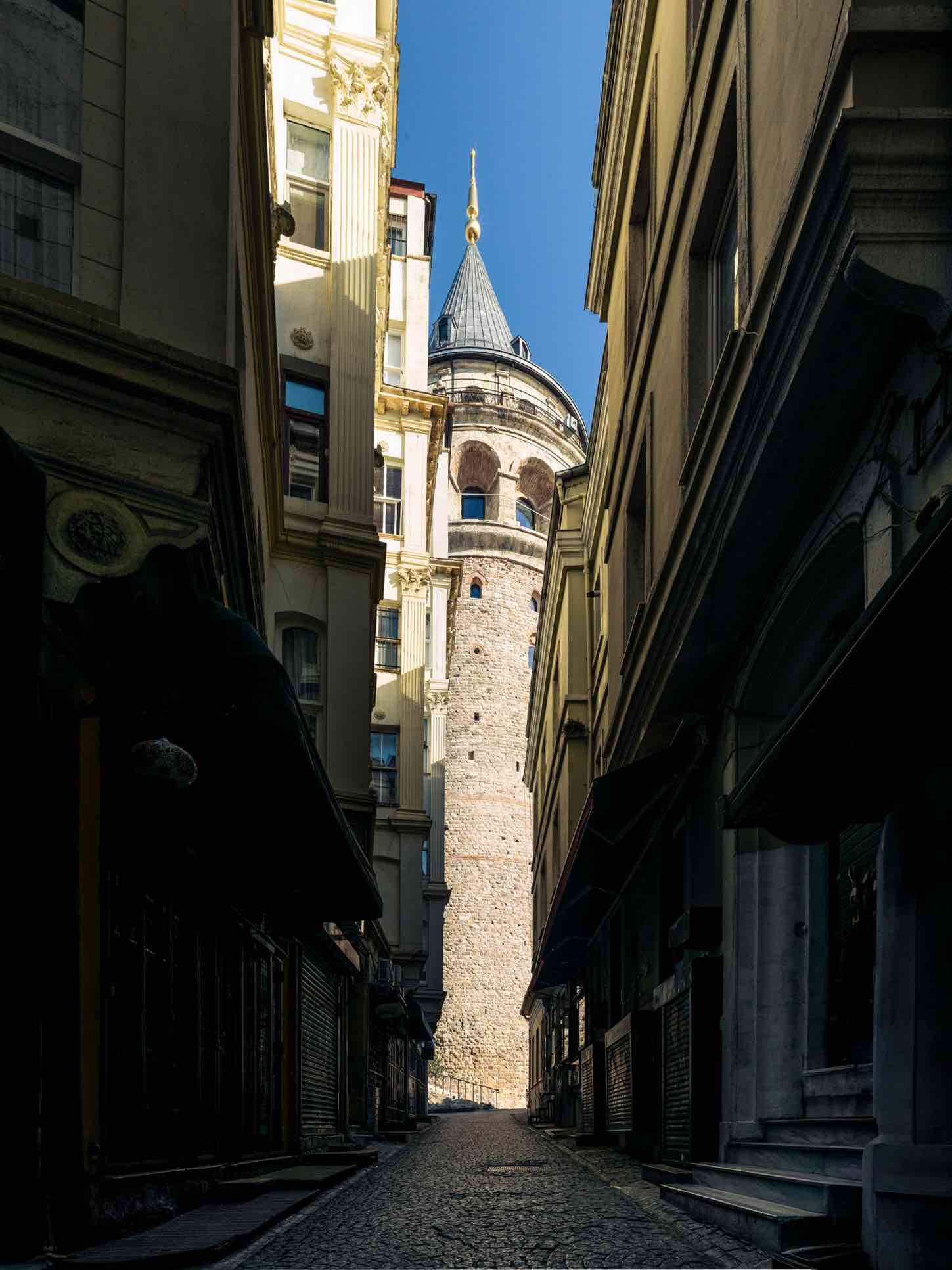 Walking uphill from Karakoy to Galata Tower through narrow streets with cafes, shops, and the tower gradually appearing in view