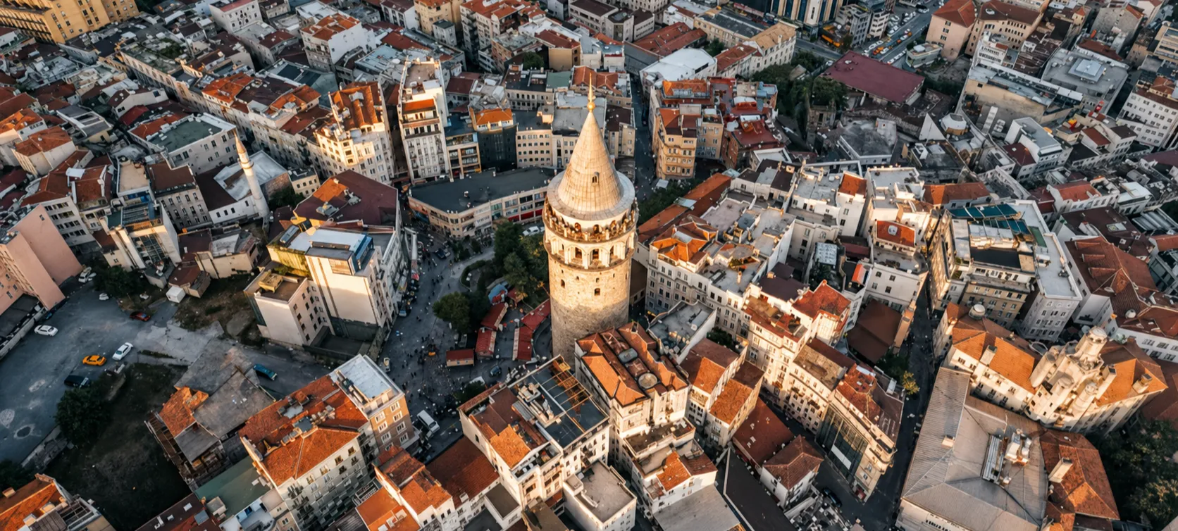 Aerial view of Galata Tower surrounded by historic rooftops and city buildings in Istanbul