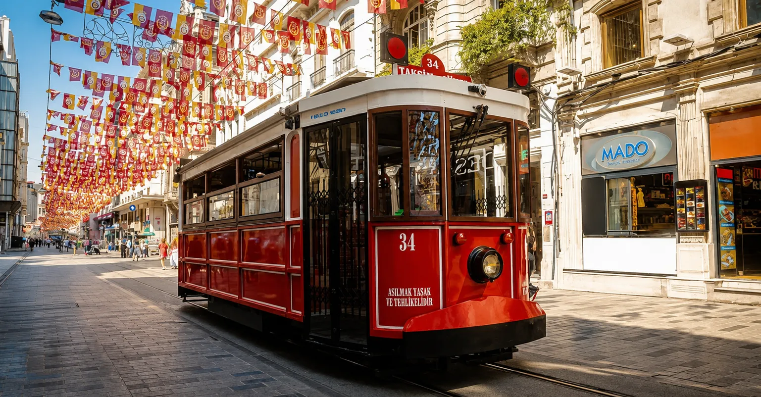 Historic red tram traveling along Istiklal Street beneath colorful flags in Istanbul
